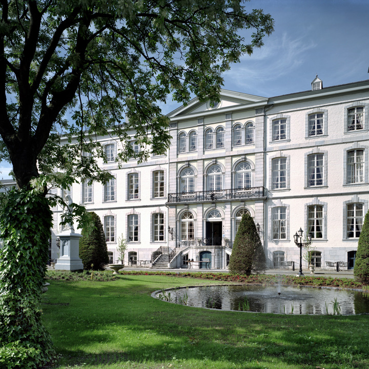 Zicht op Kasteel Bloemendal in Vaals met op de voorgrond een vijver met fontein